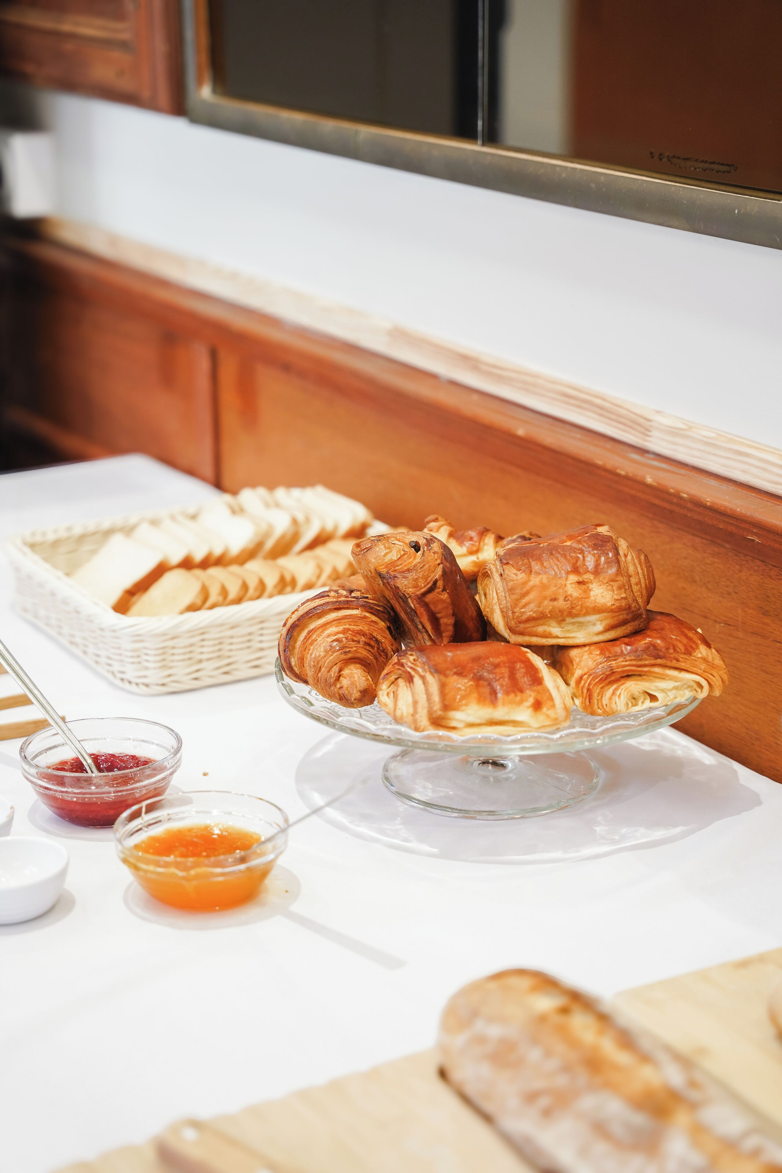 Un buffet de petit-déjeuner avec des viennoiseries et des confitures.
