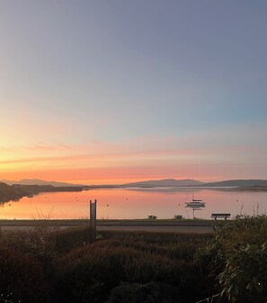 A serene lakeside view with a bench and a signpost. - Ronebhal B&B (Oban)