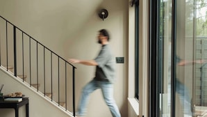 Een modern interieur met een trap, een bank en een groot raam.