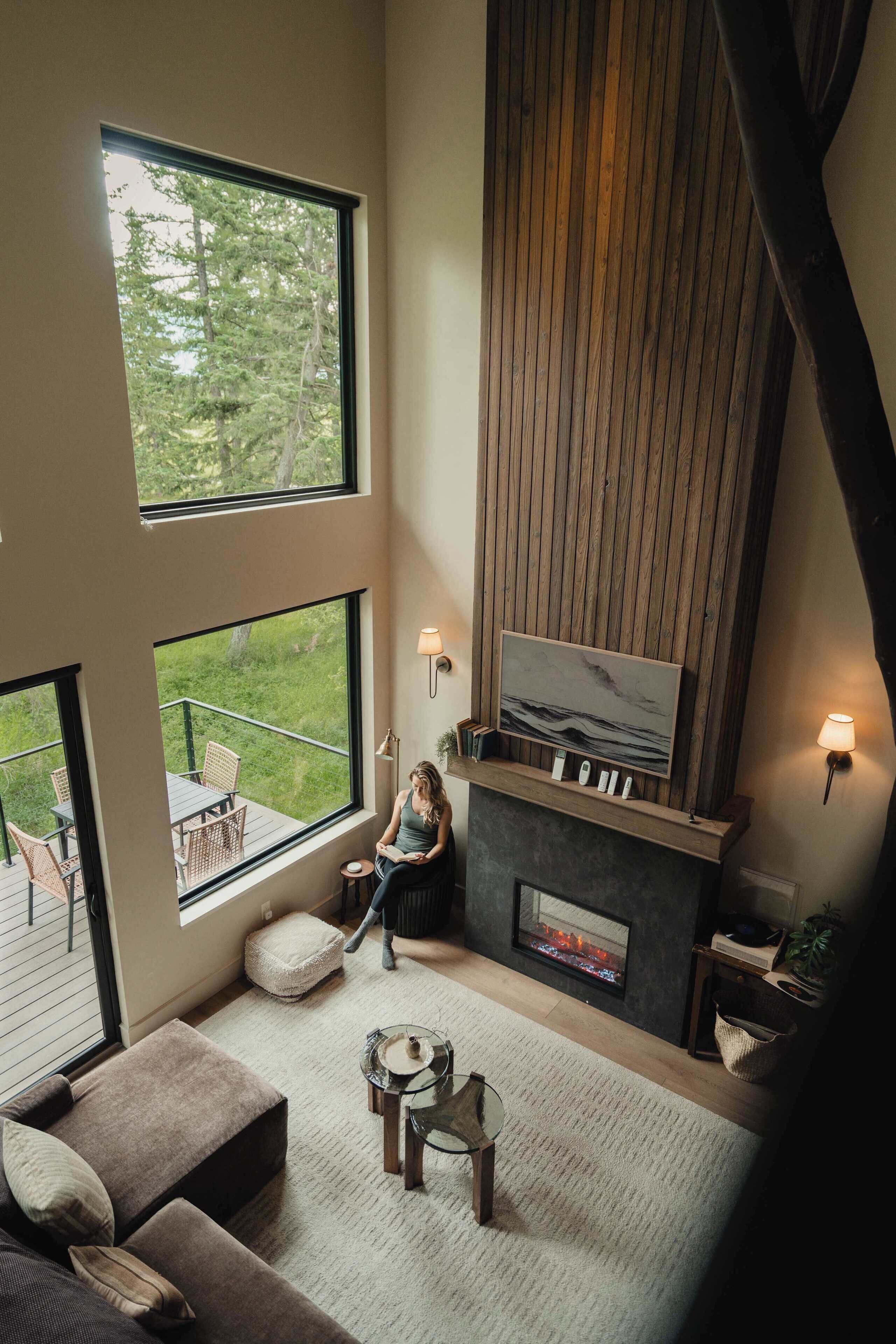 Amplia sala de estar con chimenea, ventanas grandes y un rincón de descanso acogedor.