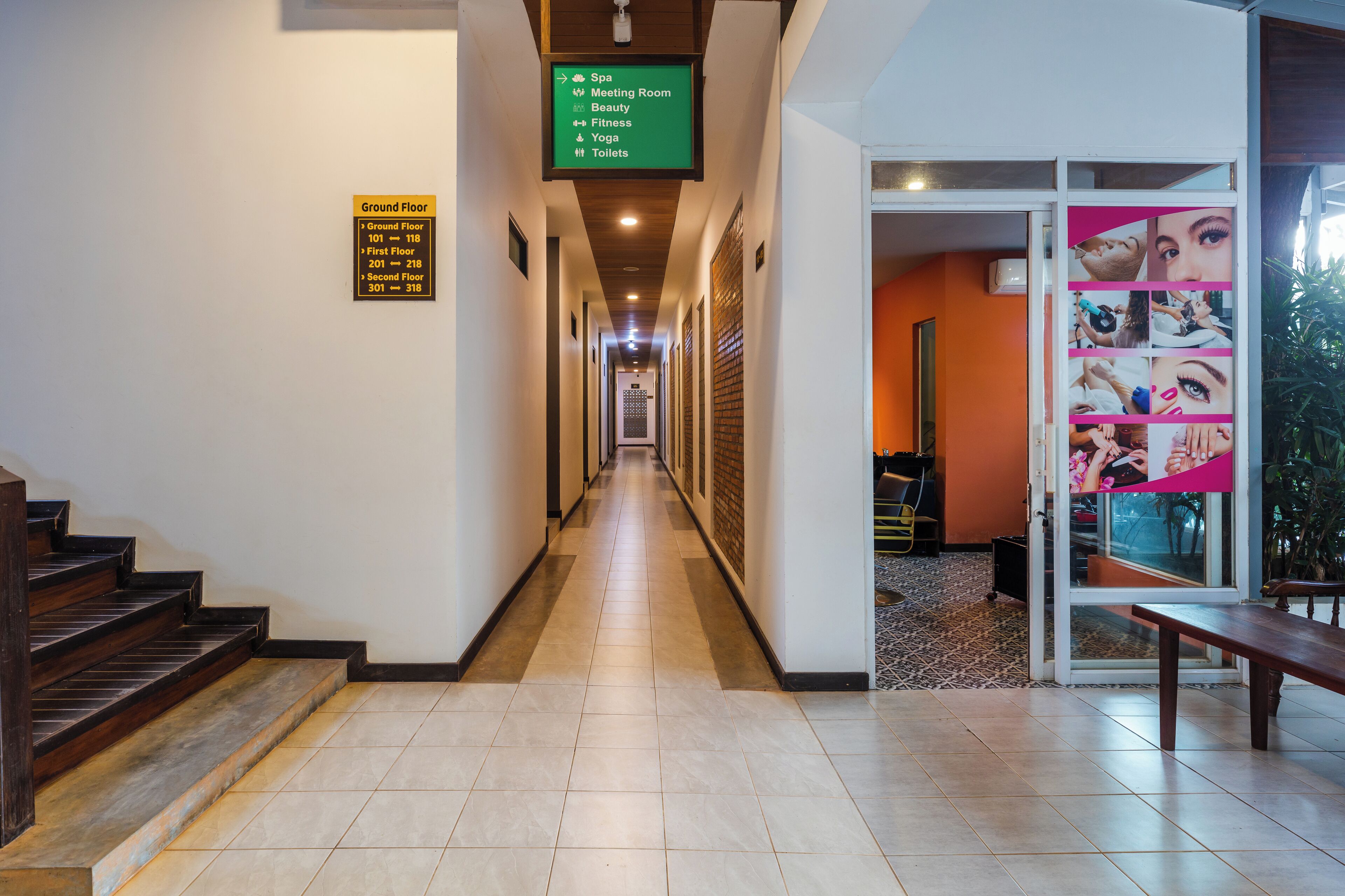 Ein Hotel-Flur mit Hinweisschildern zu Annehmlichkeiten wie Spa, Konferenzraum, Schönheit, Fitnessbereich, Yoga und Toiletten.
