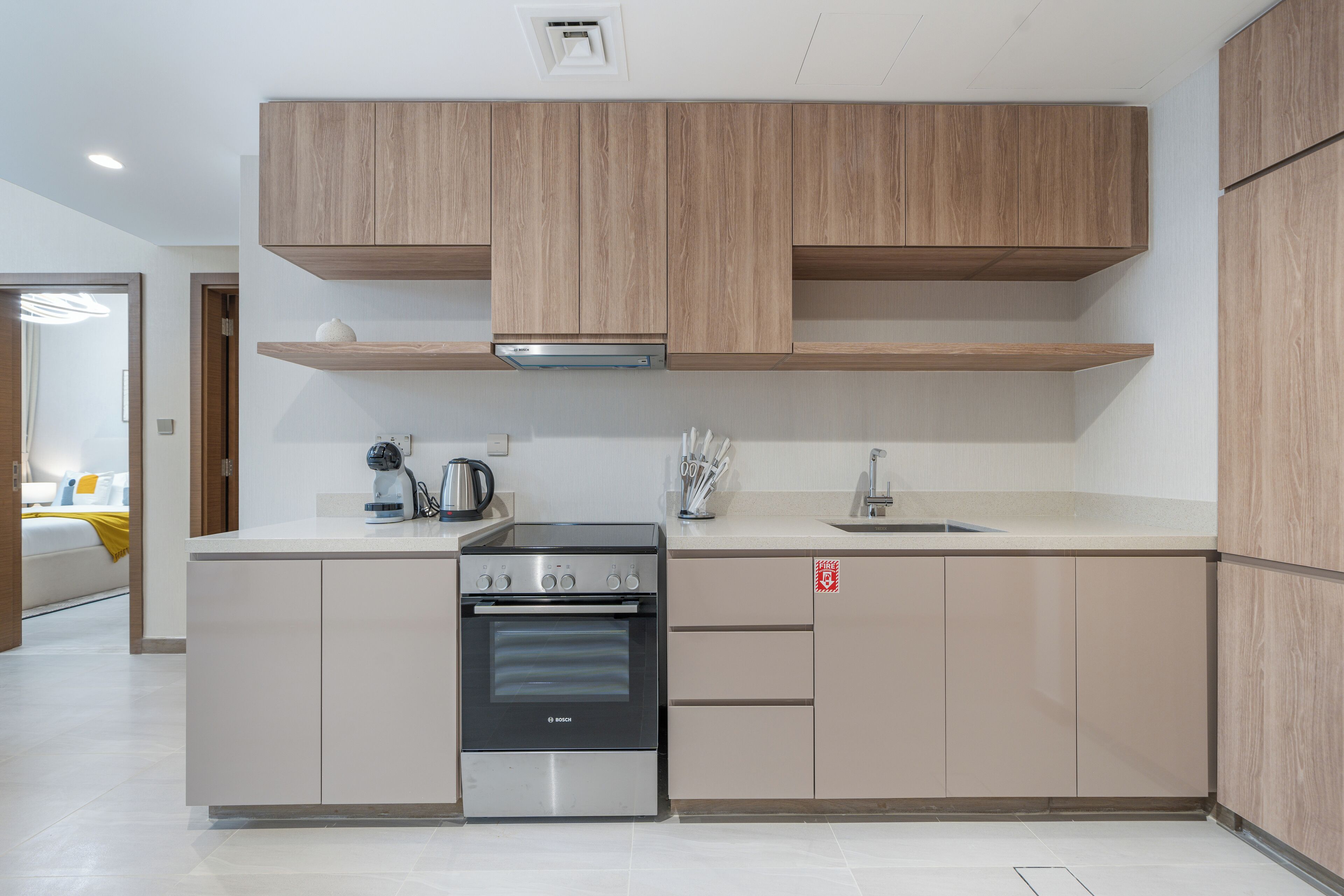 Eine moderne Küche mit Holzschränken, einem Bosch-Ofen und einer Spüle.