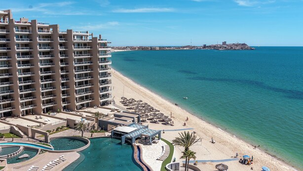 Un hôtel de grande hauteur doté d’une piscine, d’un accès à la plage et offrant une vue sur l’océan.