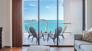 Un balcon avec vue sur la mer, comprenant une table avec des chaises et un canapé.