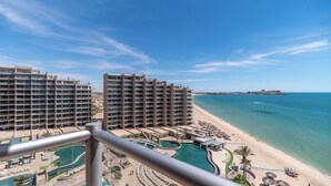 Un hôtel situé en bord de mer, composé de plusieurs immeubles de grande hauteur, doté d’une plage de sable et d’un espace piscine.