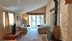 A cozy living room with two sofas, a TV, and a fireplace.