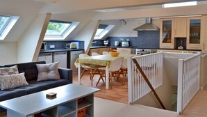 Een interieur met een eetgedeelte, keuken en woonruimte, met dakramen.