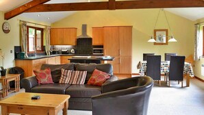 Una sala acogedora con sofá, mesa de comedor y cocina al fondo.