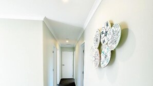 A hallway with a carpeted staircase leading to another room. - April Three Bedroom Apartment (Lake Tekapo)