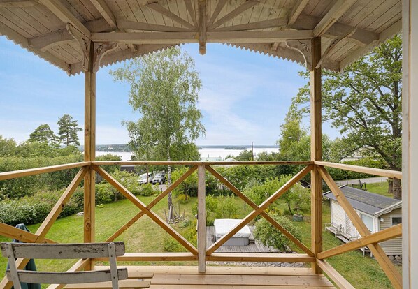 A wooden deck with a view of a lake and greenery.