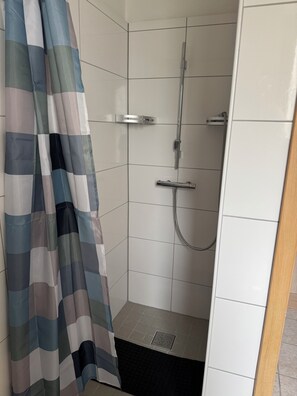 Een douche, een haardroger, handdoeken, toiletpapier