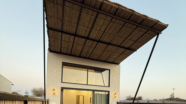 A modern house with a swimming pool, a covered patio, and a visible interior with a dining area. - Jawai Retreat - Jawai (Bali)