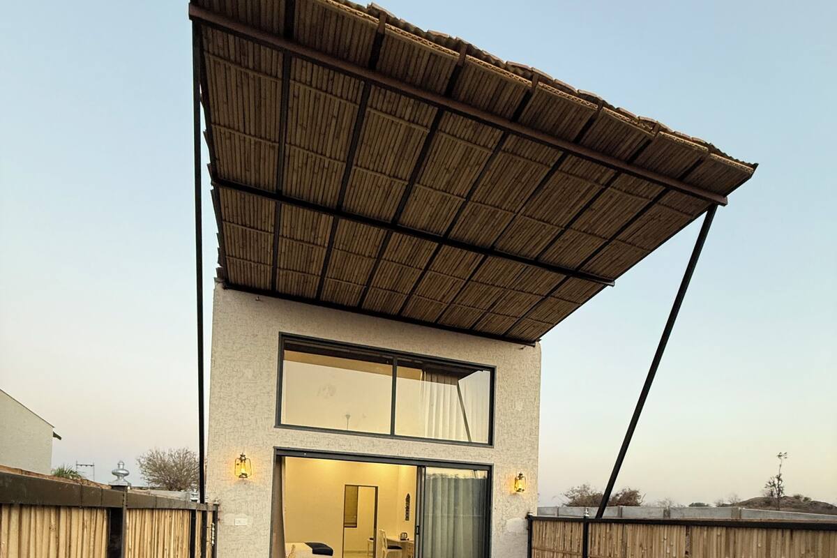 Een modern huis met een zwembad, een overdekt terras en een zichtbaar interieur met een eethoek.