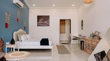 Un dormitorio moderno con cama, mesita de noche y un espacio de trabajo con silla.