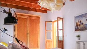 A bedroom with a bed, a wooden wardrobe, a window, and a painting on the wall. - El 8 de Serranos_bottom_house with garage (León)
