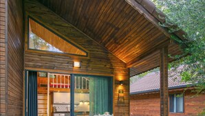 A wooden cabin with a covered porch, a kitchen area, and a dining space. - YUSALİS GARDEN HOTEL (Kumluca)