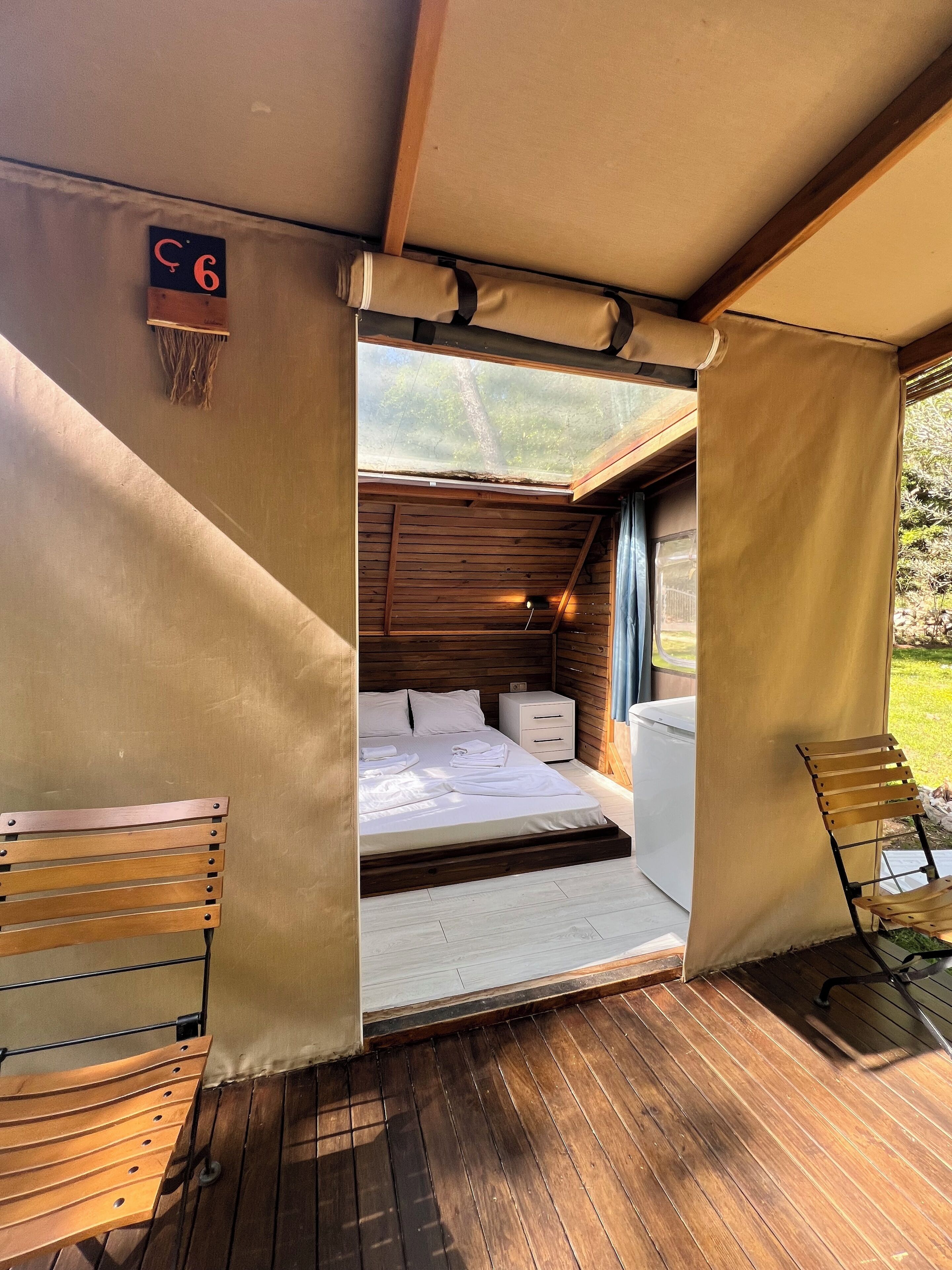 Un dormitorio de cabaña acogedor con una cama de madera, una mesita de noche pequeña y un banco.