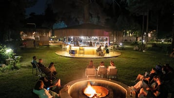 An outdoor bar area with a fire pit surrounded by seating.