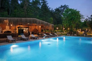 A swimming pool with lounge chairs and a thatched-roof structure. - YUSALİS GARDEN HOTEL (Kumluca)