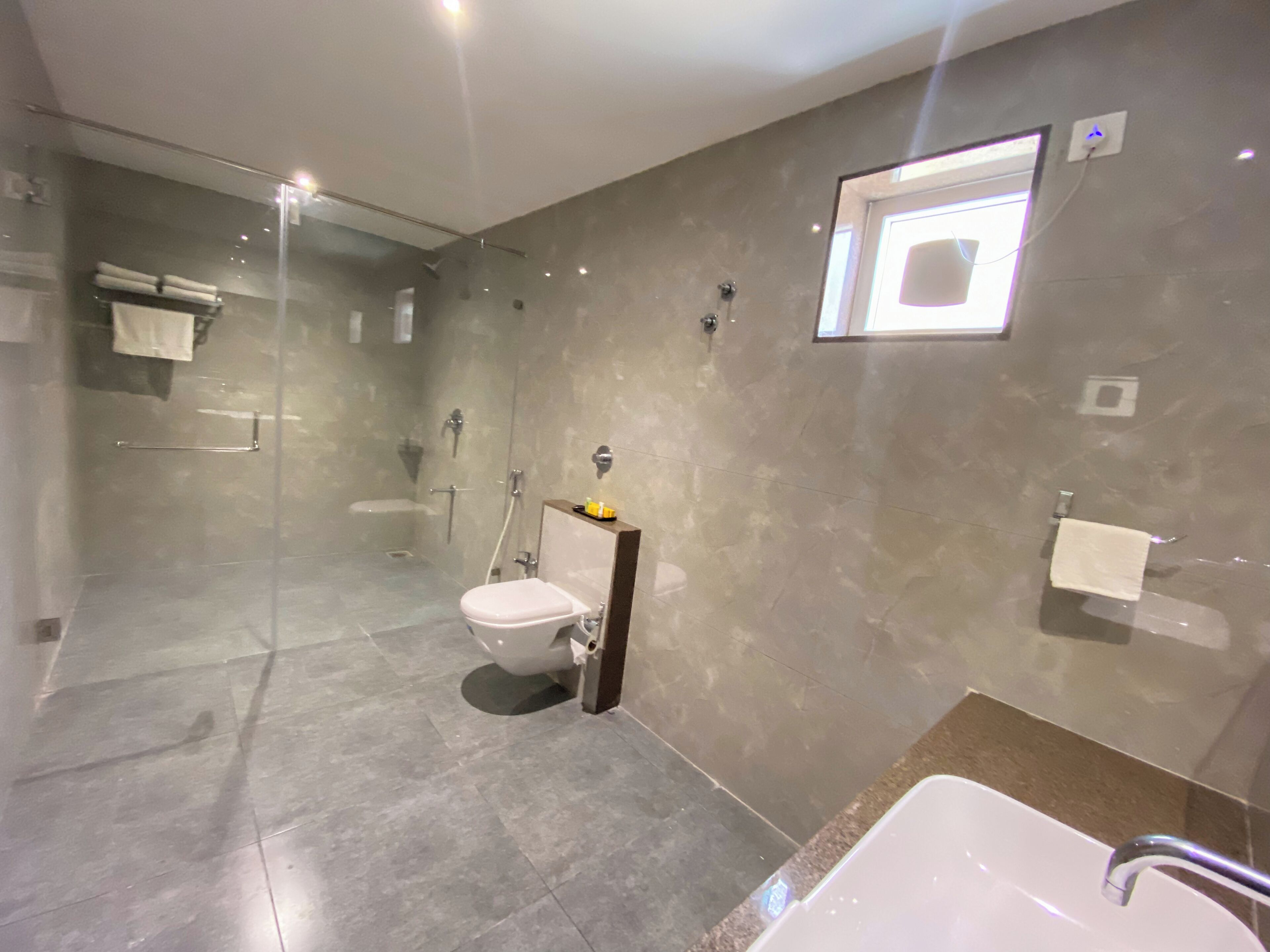 Un baño moderno con ducha de vidrio, inodoro y lavamanos.