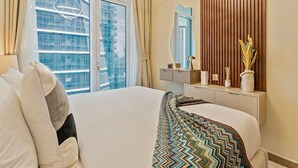 Une chambre d’hôtel avec un grand lit, une fenêtre avec des rideaux, un miroir et un mur recouvert de panneaux de bois.