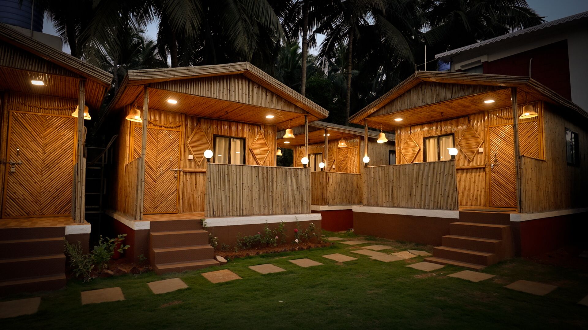 A wooden cabin-style building with a covered patio area, steps leading to the entrance, and a well-maintained lawn.