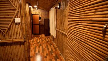 A narrow hallway with wooden walls and a checkered floor.