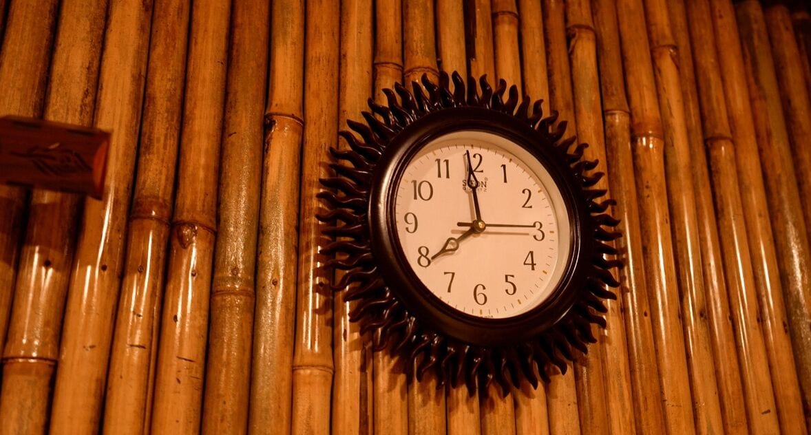 A wall-mounted clock with a bamboo background.