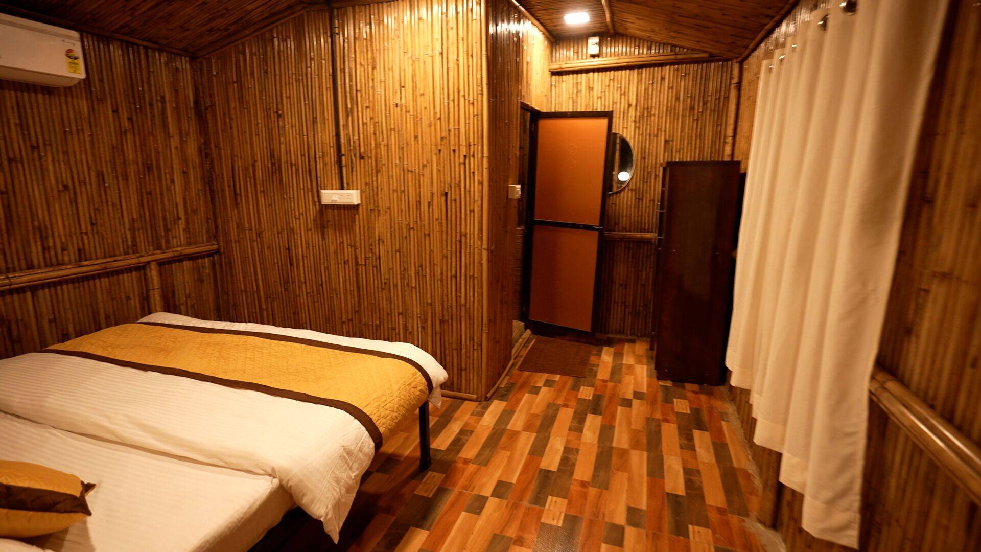 A room with a bed, a mirror, and a door.