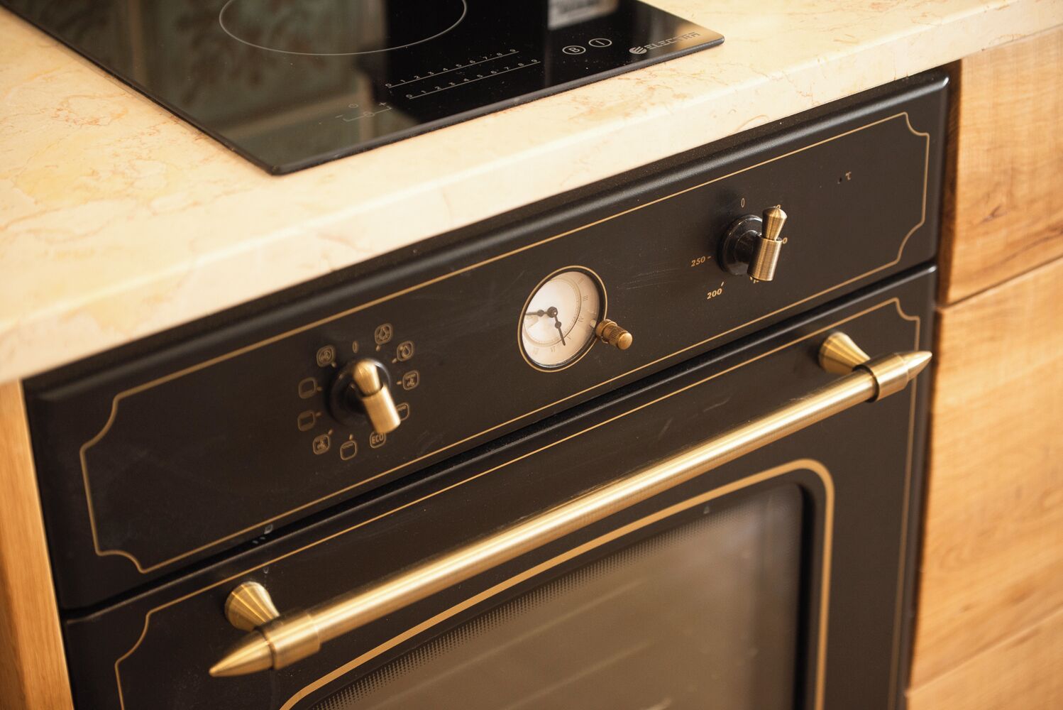 Una cucina con forno integrato, un pannello di controllo con manopole e un quadrante, e una maniglia in acciaio inossidabile.