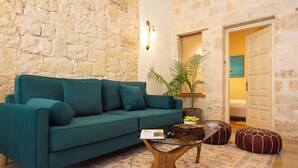 Un salon chaleureux avec un canapé de couleur turquoise, une table basse et une plante en pot.