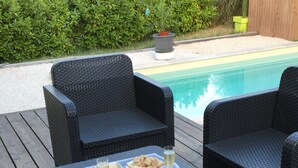 Une terrasse dotée de meubles en osier et d’un plateau rempli de nourriture et de boissons.