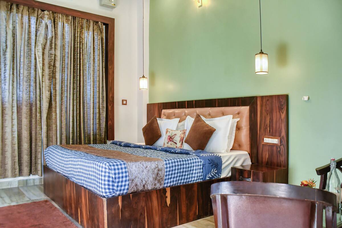 A bedroom with a wooden bed, checkered bedspread, and two hanging pendant lights.