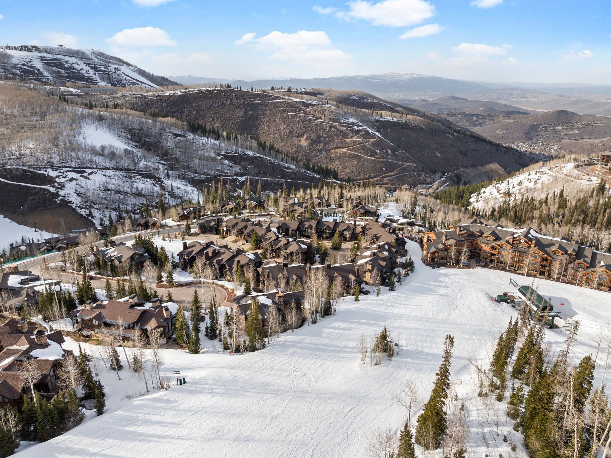 A ski resort with multiple lodges, a ski slope, and surrounding mountainous terrain.