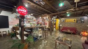 Ein gemütliches Interieur mit einem Coca-Cola-Schild, Holzmöbeln und einem roten Sofa.