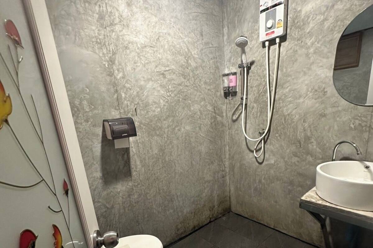 A bathroom with a toilet, a sink, and a shower.