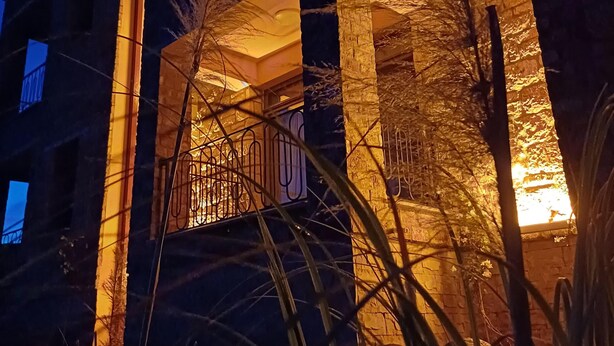 A multi-story building with illuminated balconies and a warm glow from the windows. - İda Lythos (Ayvacik)