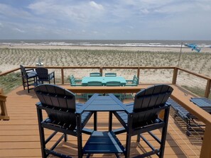 Une terrasse avec des sièges extérieurs donnant sur une plage.