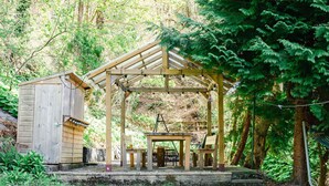 A wooden pergola with a table and chairs, surrounded by a lush garden and a small shed. - Nice apartment for 2 guests with WIFI, TV and patio (Inverness)