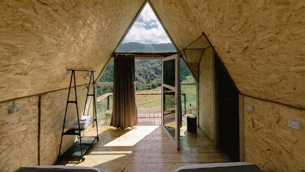 A triangular wooden room with a view of a forested landscape. - OKON Highlands Cottages & Camp (Yenokavan)