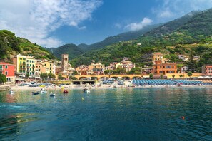 A coastal town with colorful buildings, a tower, and boats on the water. - Graceful House in Monterosso (Monterosso al Mare)