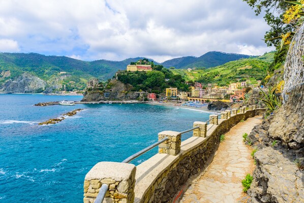 A coastal town with stone buildings, a stone pathway, and a view of the sea and mountains. - Monterosso Apartments (Monterosso al Mare)