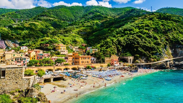 A coastal town with a beach, colorful buildings, and a bridge. - Monterosso Apartments (Monterosso al Mare)