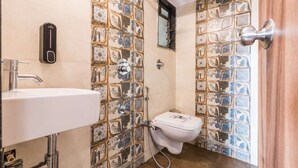 Ein Badezimmer mit gefliesten Wänden, Toilette, Waschbecken und Dusche.