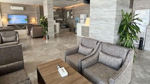 Ein geräumiger Wohnbereich im modernen Design mit einer großen Couch, einem Couchtisch und einem Fernseher.