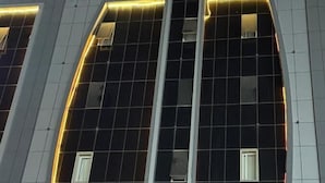 Ein Gebäude mit moderner Architektur, das ein markantes Schild mit beleuchteten Buchstaben zeigt.