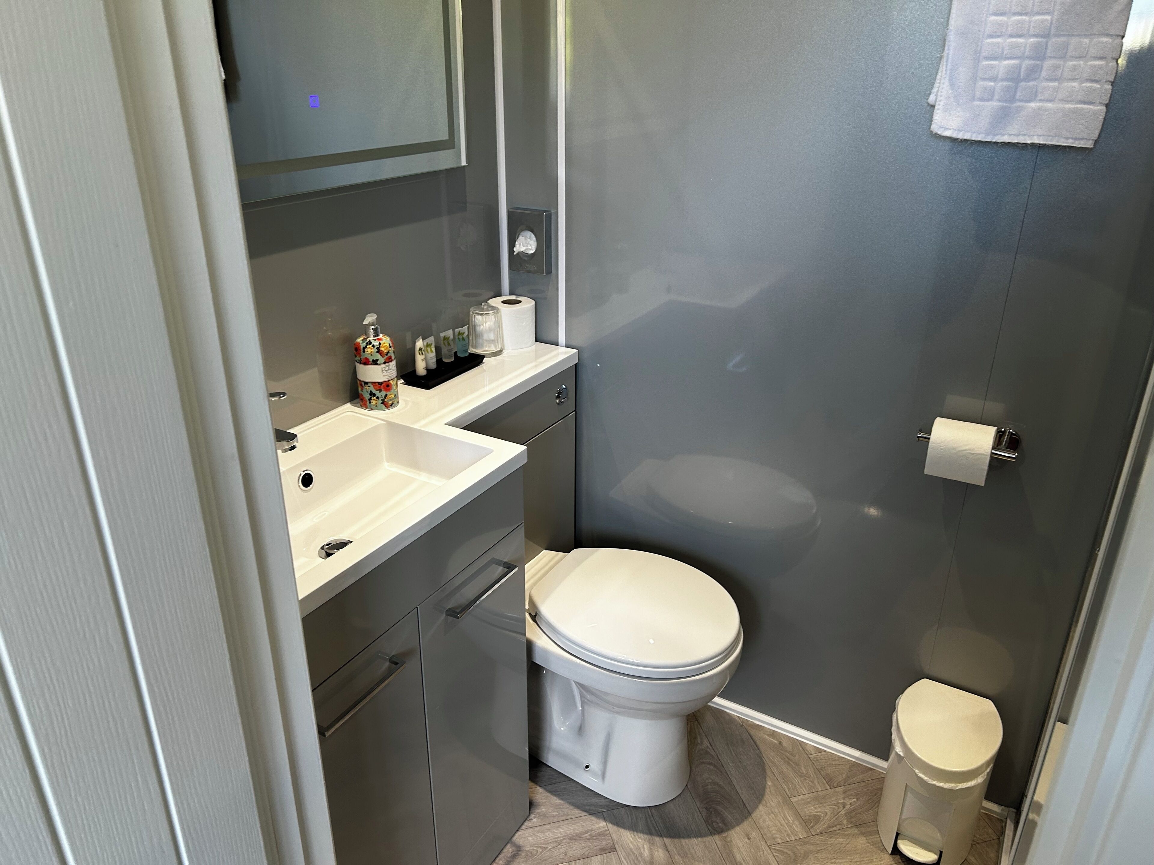 A modern bathroom with a white sink, toilet, and bidet.