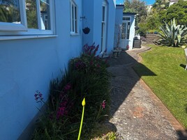 Un sendero que lleva a una casa azul con jardín.