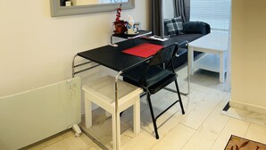 A compact room with a bed, a desk, and a chair. There is a window with curtains, a radiator, and a painting on the wall. - Brighton charm – Near Beach, City Centre & Station (Brighton and Hove)