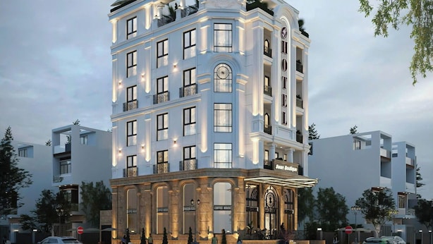 A multi-story hotel with a classic architectural design, featuring balconies and large windows.